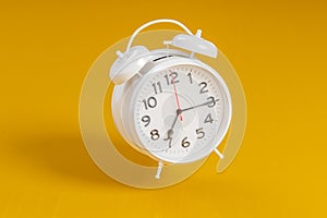 White vintage alarm clock on bright orange color background. Time management, deadline concept. 3d rendering