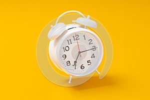 White vintage alarm clock on bright yellow color background. Time management, deadline concept. 3d rendering