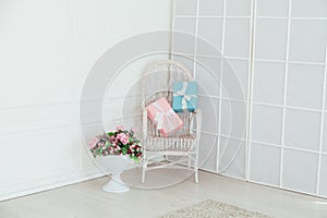 White vintage chair with gifts in the interior of a white empty room