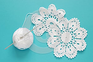 White vintage crochet doily. Cotton yarn for knitting, crochet hook