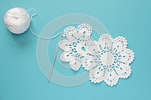 White vintage crochet doily. Cotton yarn for knitting, crochet hook