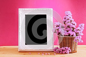 White vintage photo frame with sweet statice flower in basket wi