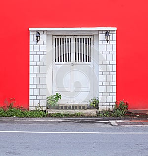 White vintage retro wooden door on red wall background. Home interior architecture design, plain tropical textured wood panel