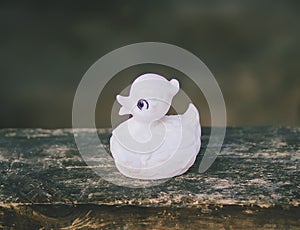 White vintage toy duck on wooden bench