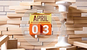 White vintage wood block calendar present date 03 and month April on blue wooden table