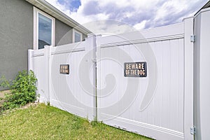 White vinyl fence gate with two beware of dog the signages