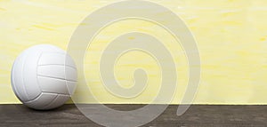 White volleyball ball isolated on yellow background. Team sport concept