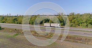 A white wagon drives along the highway in good weather. The truck drives along the highway in sunny weather. The wagon