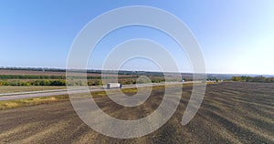 A white wagon drives along the highway in good weather. The truck drives along the highway in sunny weather. The wagon