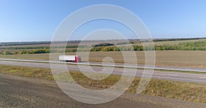 A white wagon drives along the highway in good weather. The truck drives along the highway in sunny weather. The wagon