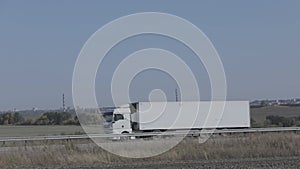 A white wagon drives along the highway in sunny weather. Truck on the highway