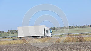 A white wagon drives along the highway in sunny weather. Truck on the highway