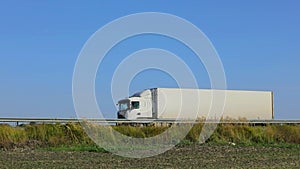 A white wagon drives along the highway in sunny weather. Truck on the highway