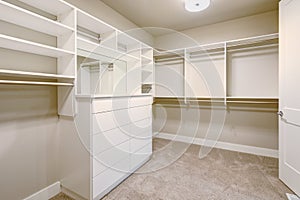 White walk-in closet with shelves, drawers and clothes rails