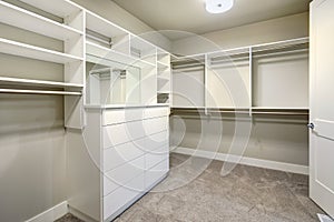 White walk-in closet with shelves, drawers and clothes rails