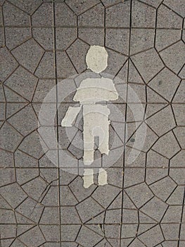 White-walk way man symbol sign on concrete ground in public park