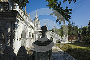 White wall with archs and garden of Atumashi Monastery, formally Maha Atulaveyan Kyaungdawgyi - Buddhist monastery