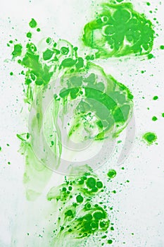 White wall with chaotic green paint drops