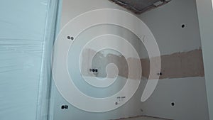 White Wall with Circular Electrical Outlets Junction Boxes in the Wall. Installation Plastic Box for Electrical Wiring