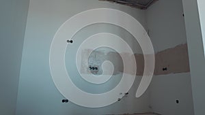 White Wall with Circular Electrical Outlets Junction Boxes in the Wall. Installation Plastic Box for Electrical Wiring