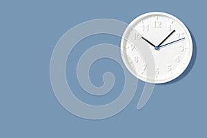 White wall clock on pastel blue background