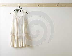 White wall and clothes on a hanger.