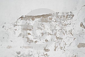 White wall with cracked plaster in middle of frame. Cracks and destruction texture rough background, copy space