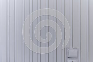 A white wall with a white door and a white switch