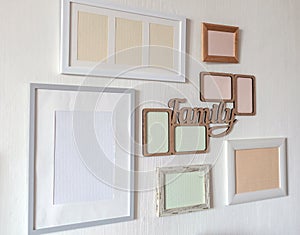 White wall with set of different empty vertical and horizontal frames to create family photo gallery