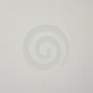 White wall surface with fine, visible hairline cracks. The texture is smooth and slightly