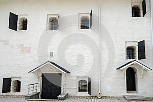 White wall with vintage wrought iron window shutter in a special arch niche. Window of an old building of 17th century