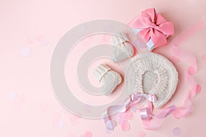 White warm handknitted baby shoes and bonnet for little girl or boy and gift box - concept of first step, birthday party, baby