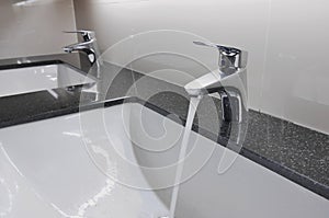 White washbasins and faucet on granite counter