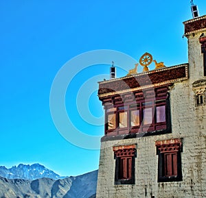 a white washed buddhist monastery with traditional architecture in ladakh