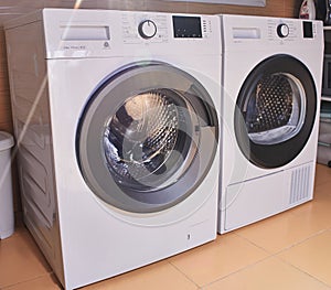 White washer and dryer with shiny clean drums located in an environmentally friendly laundry photo