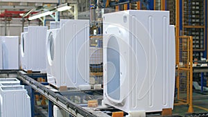 White washing machine body moving on production conveyor at industrial factory