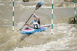 White water kayak athlete racing through a downstream slalom gate