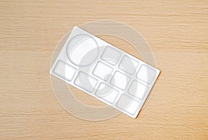 White watercolor palette. Empty watercolor tray  on wood background. White paint palette