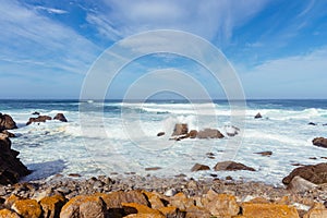 White waves hitting rocks on the ocean shore