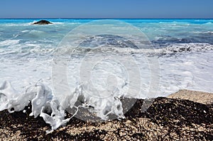 White waves over black seaweed and algae