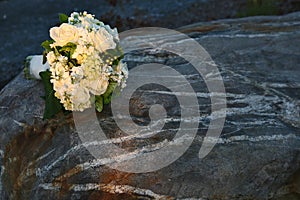 White wedding bouquet sitting on a rock