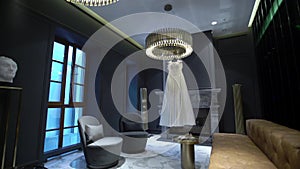 White wedding bridal dress near fireplace in luxury hotel interior