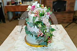 White wedding cake decorated by flowers fruits