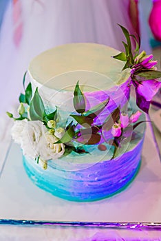 White wedding cake decorated by flowers fruits