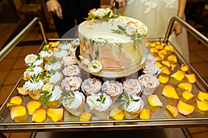 White wedding cake decorated by flowers fruits