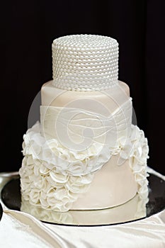 White wedding cake decorated with white pearls