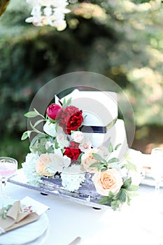 White wedding cake with red peony.