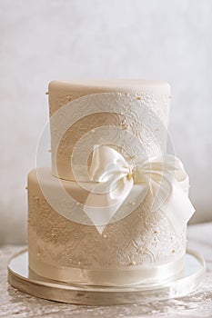 White wedding cake. Wedding cake detail - a ribbon with pearls