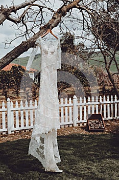 White wedding dress hanging outside
