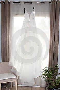 White wedding dress hanging on a window